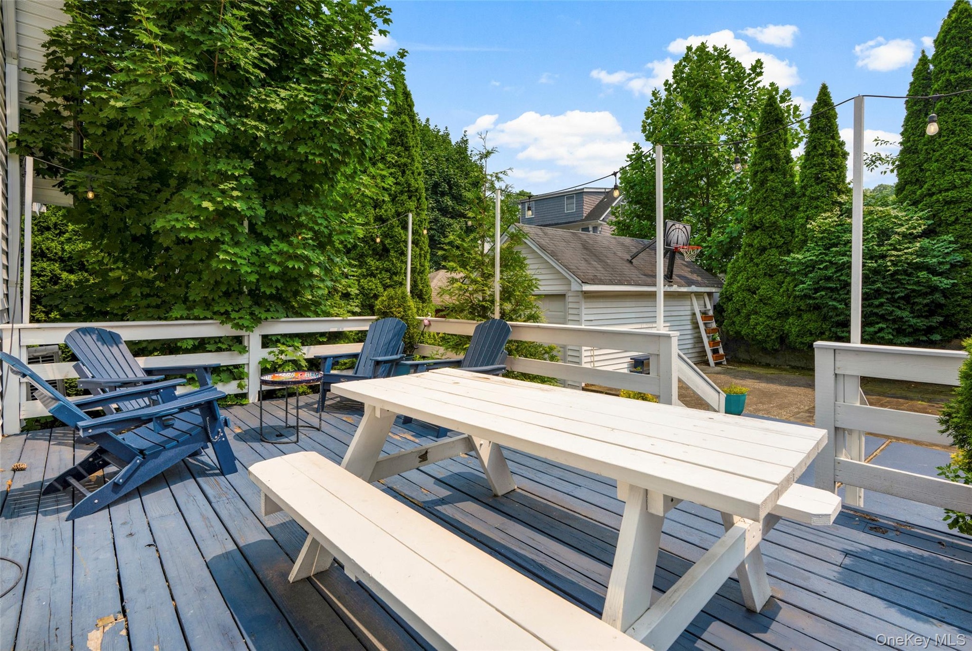 Spacious outdoor deck featuring painted wood flooring and white railings.