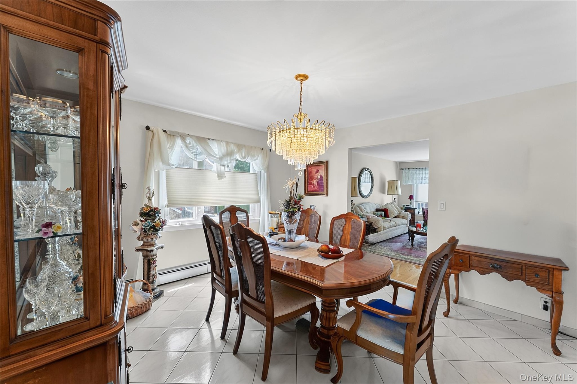 Dining area featuring a prominent crystal chandelier and tile flooring