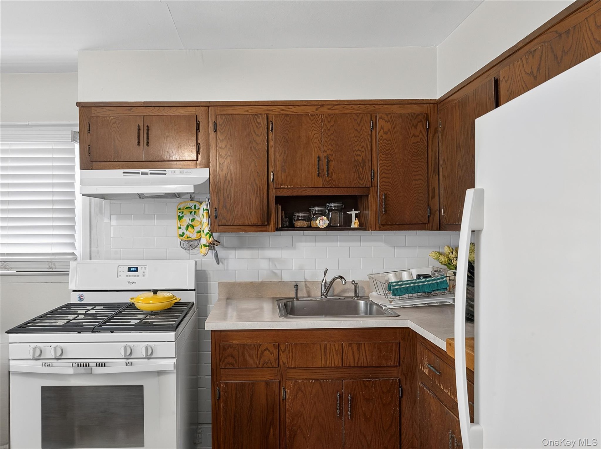 Kitchen with wood-finish cabinetry and white appliances