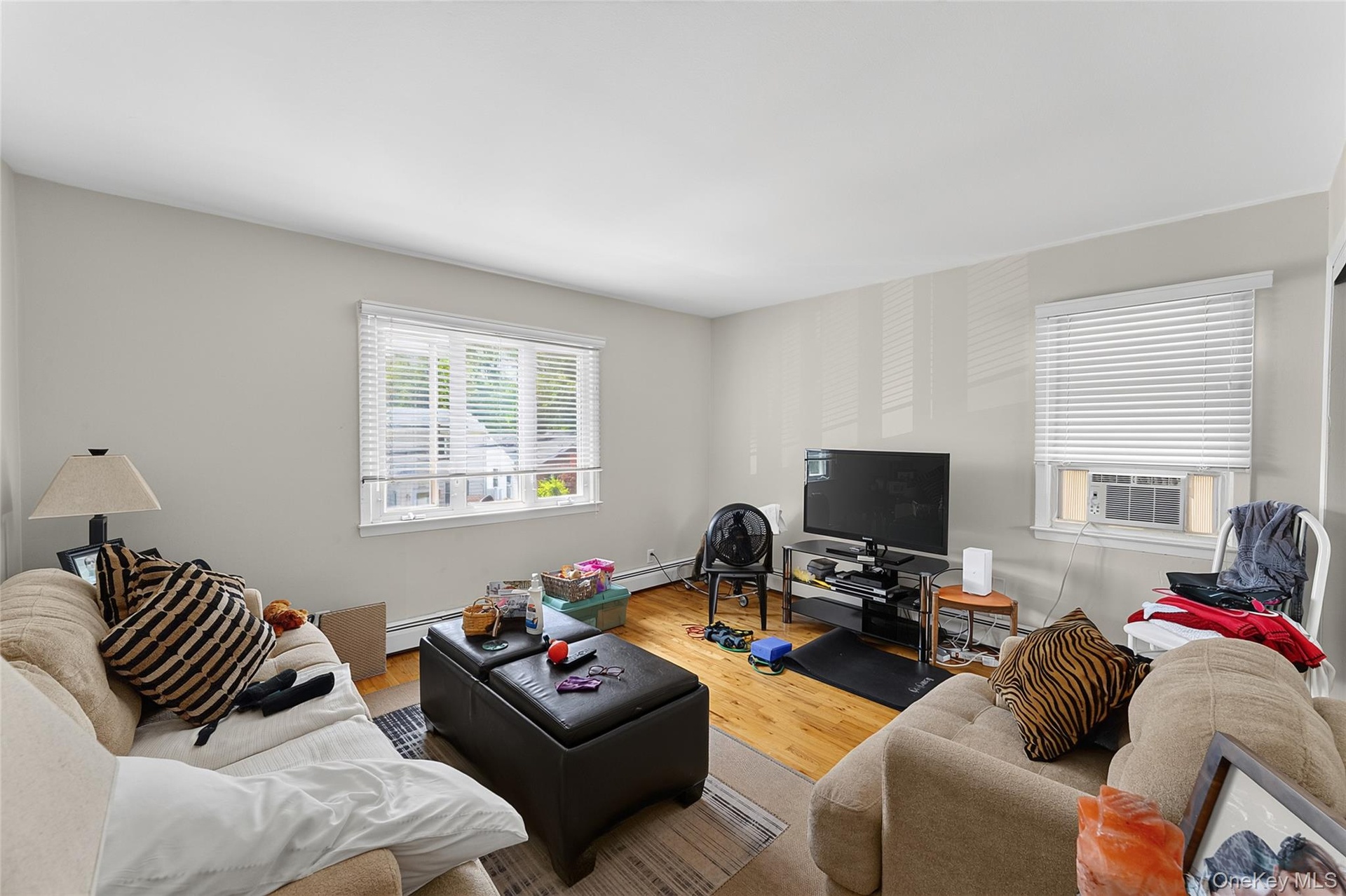 Living area featuring wood-finish flooring, light neutral wall paint, and white trim