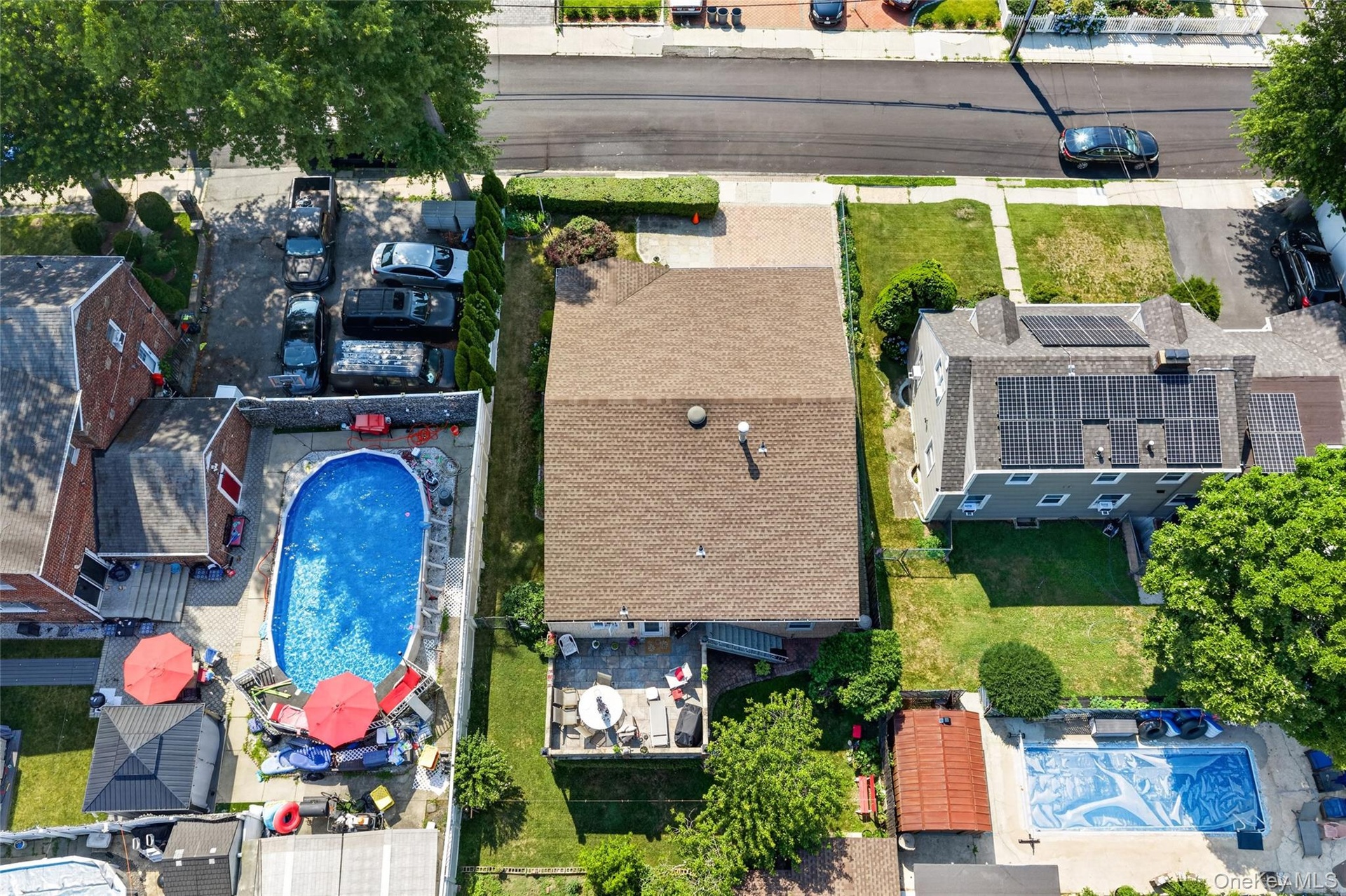 Expansive residential property featuring a large backyard patio, a well-maintained lawn, and mature trees