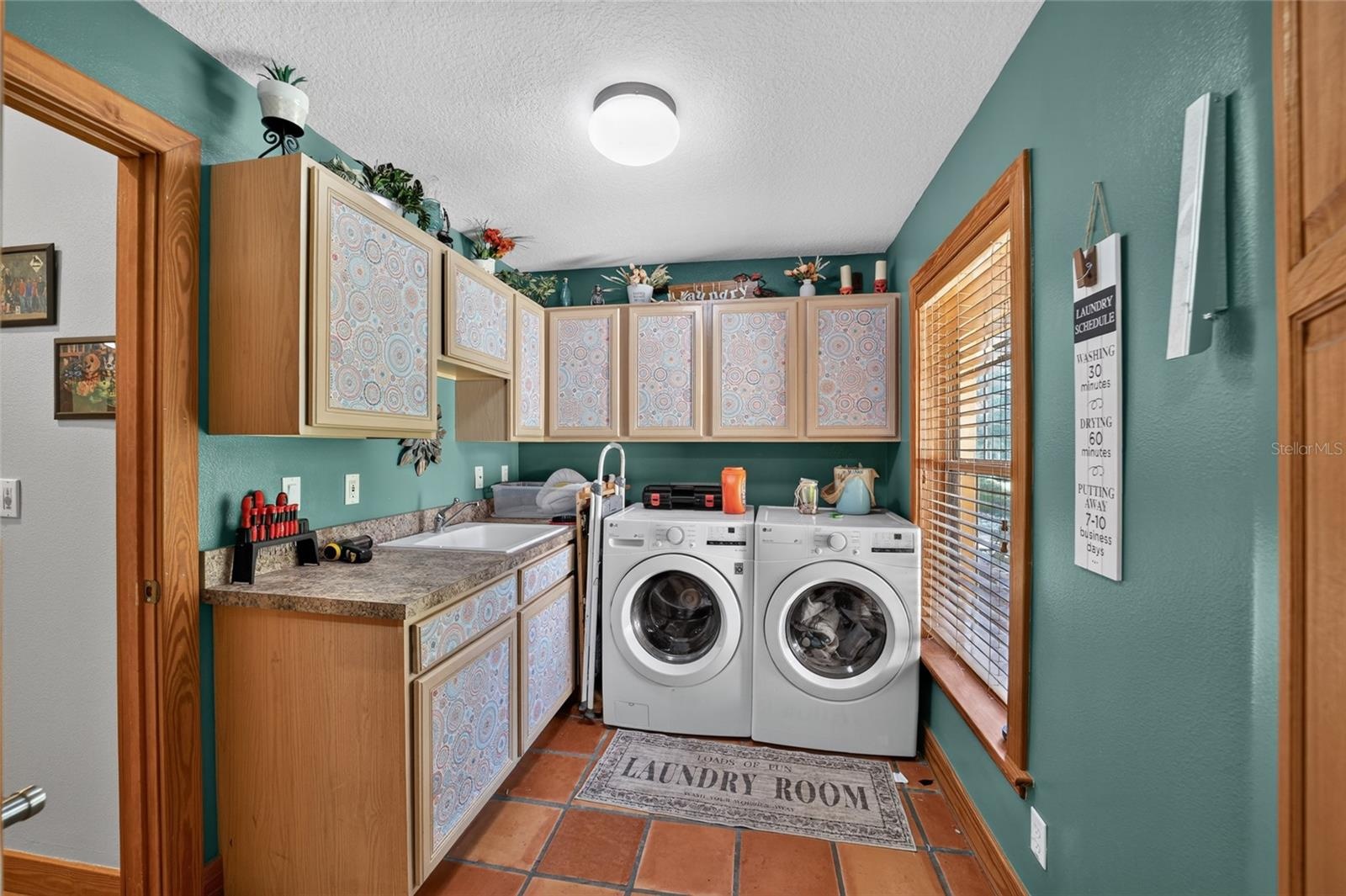 Spacious Laundry Room with Utility Sink & Abundant Cabinet Storage