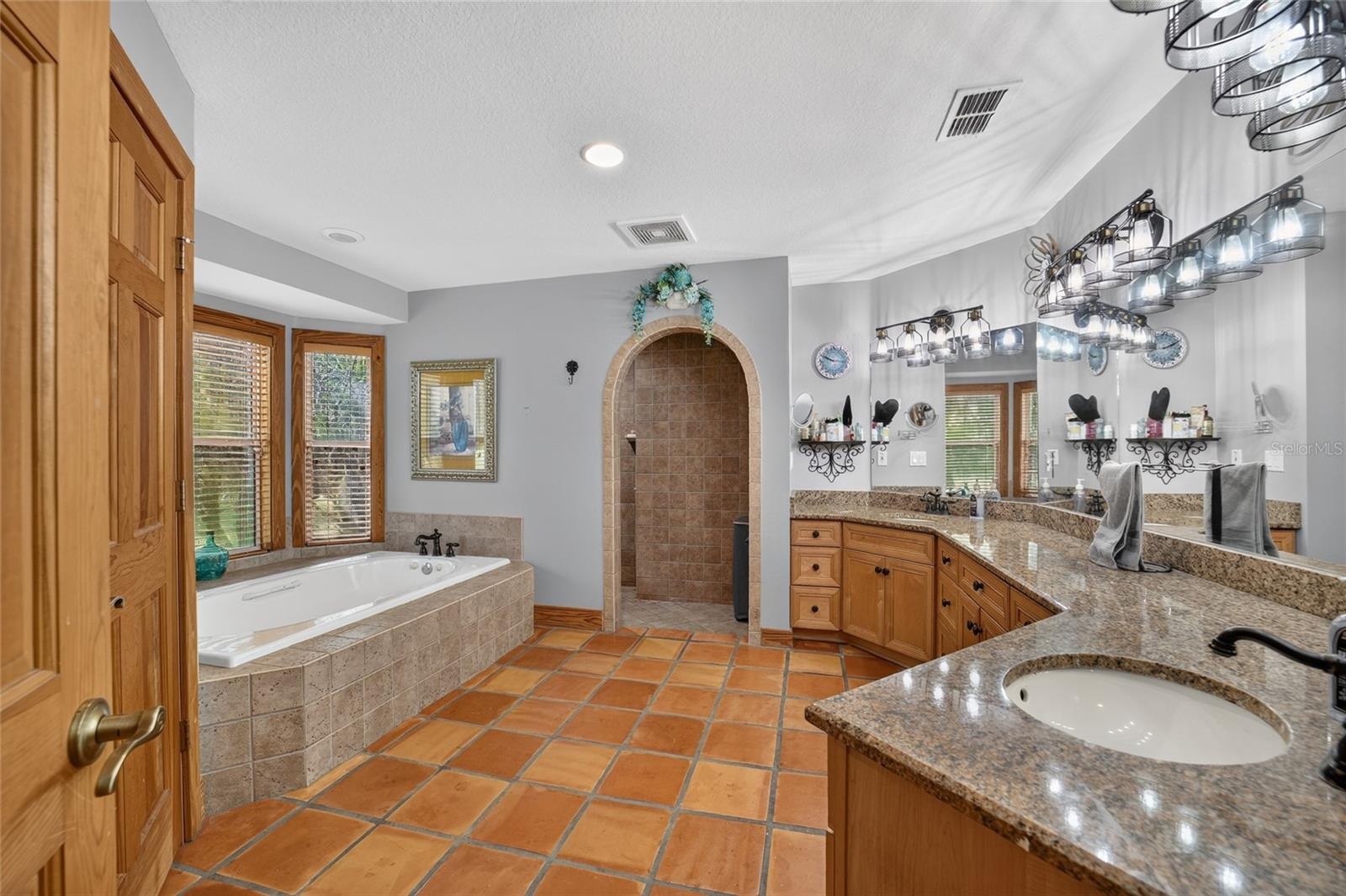 Spa-Inspired Primary Bathroom with Large Soaking Tub, Oversized Walk-In Tiled Shower, Dual Vanities & Private Water Closet