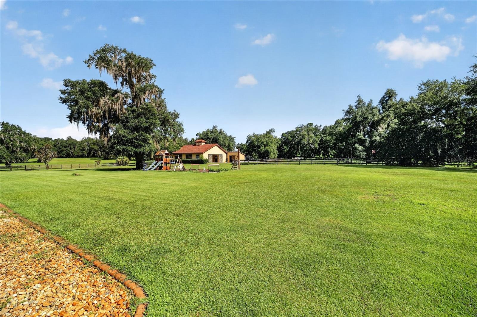 Groomed Backyard with Playground and 5-Stall Center-Aisle Barn