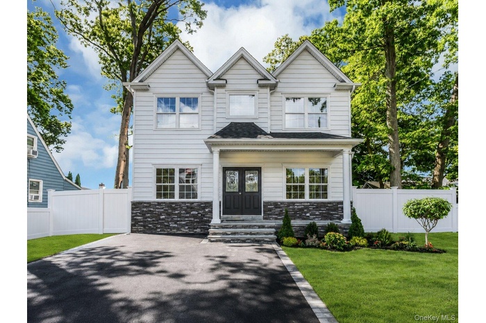 Colonial features: stacked stone detail front covered porch, asphalt double driveway, professionally landscaped with inground sprinklers