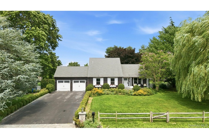Exterior featuring a dark siding, white shutter accents, a gray shingle roof, and a two-car garage with white doors