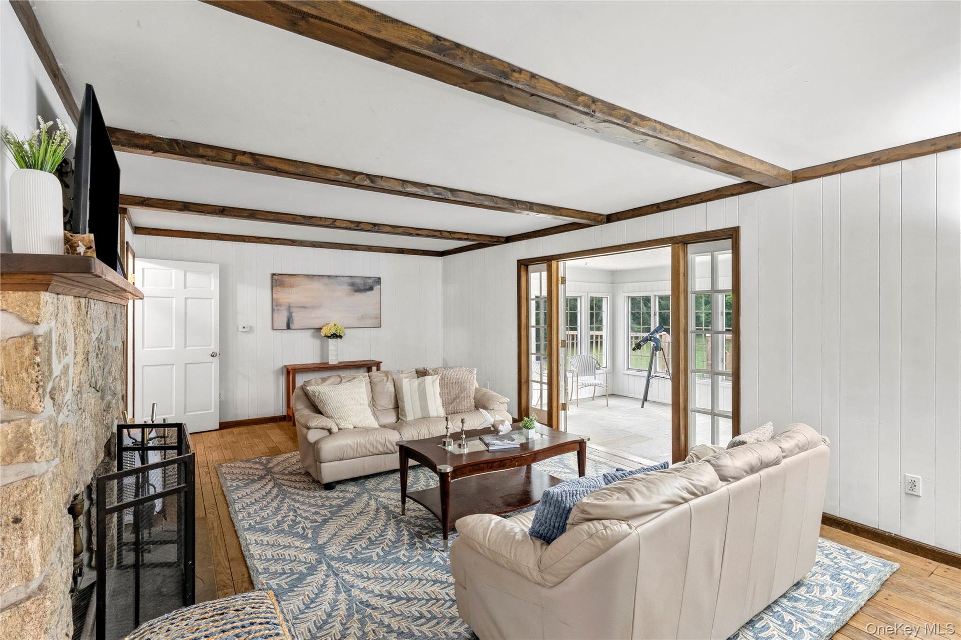 Warm and comfortable great room with wood exposed beams and fireplace for year round relaxation.