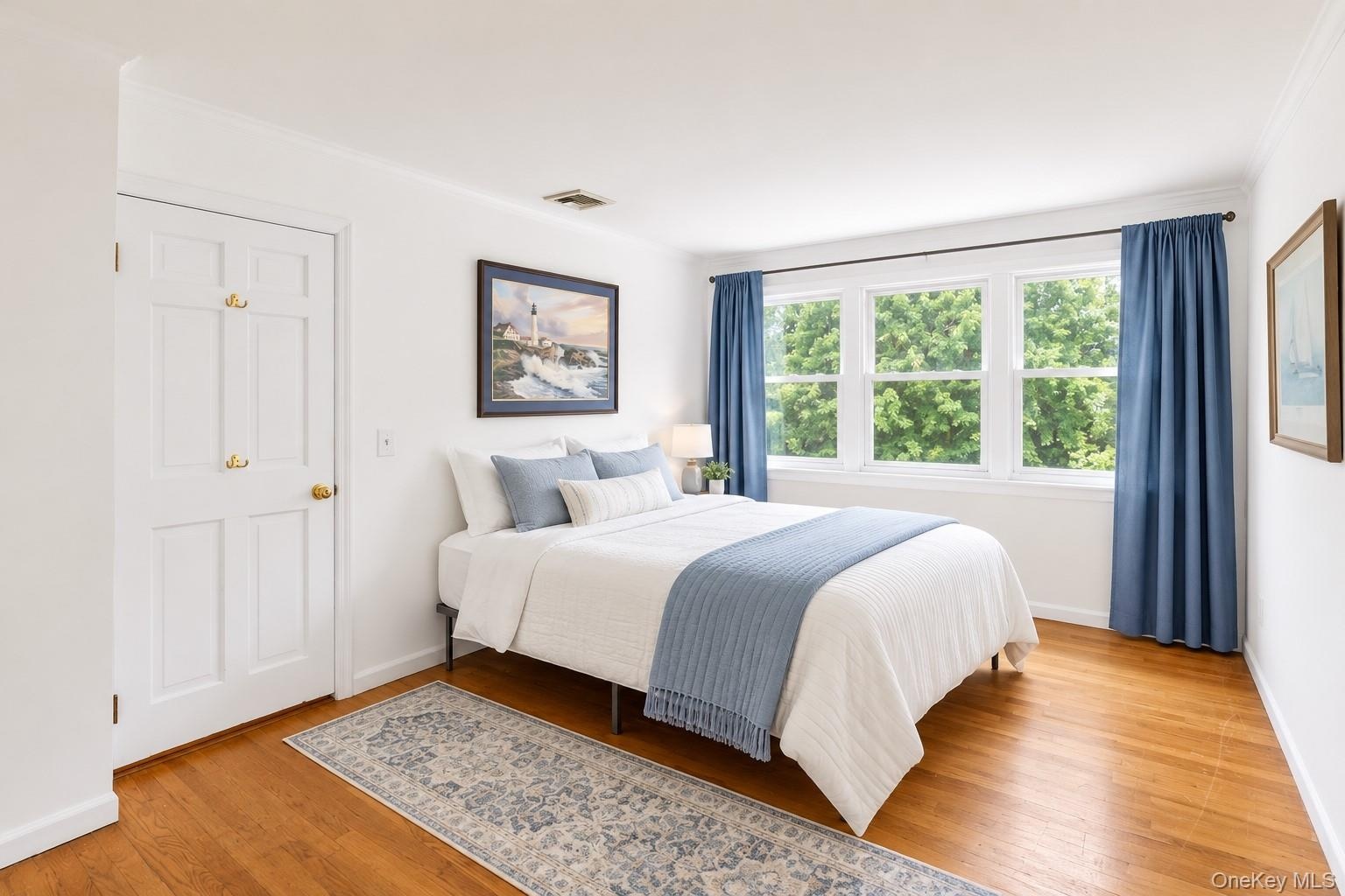 Second floor bedroom with abundant light and backyard garden views.