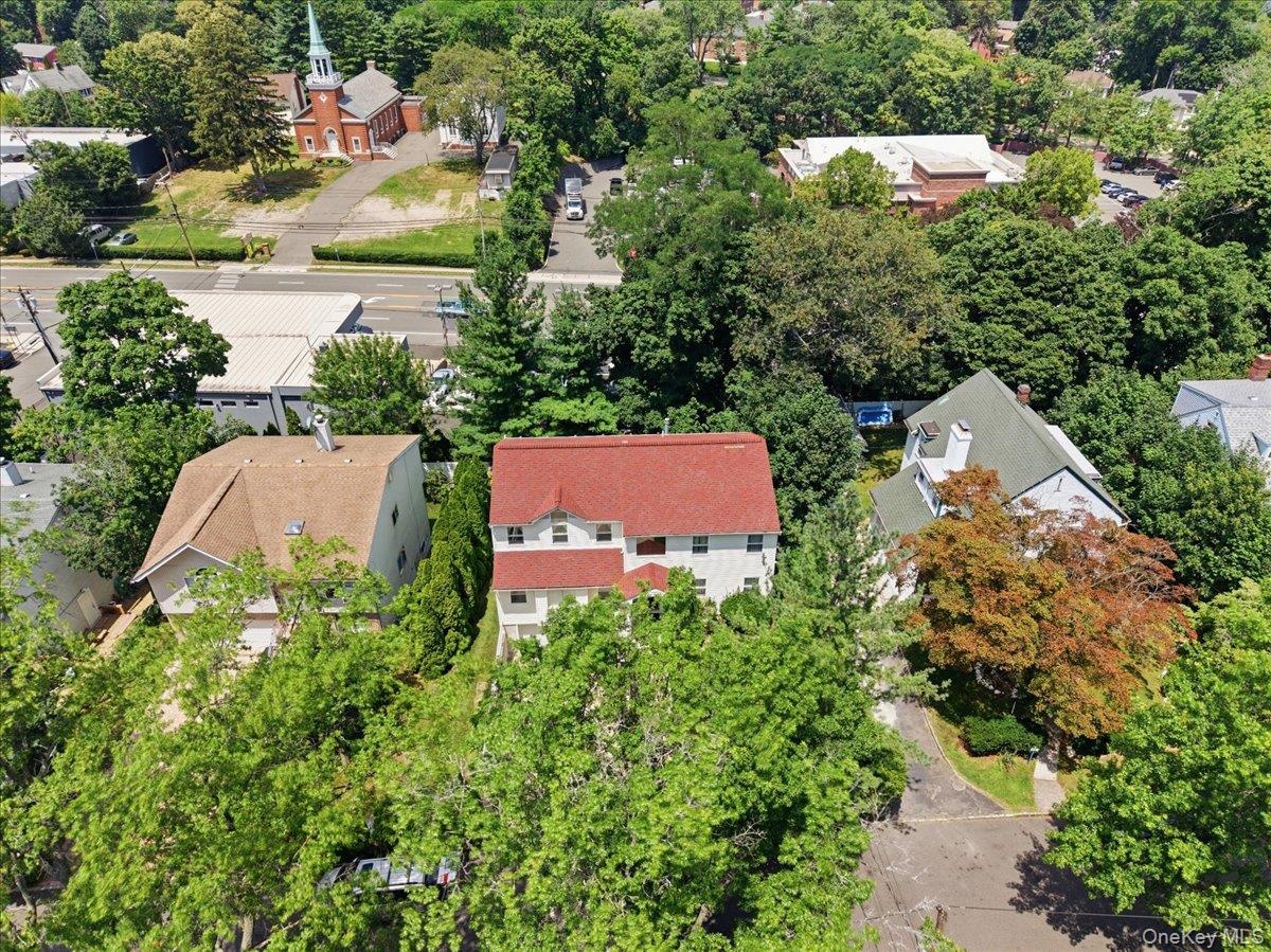 White multi-story residence featuring a red shingled roof