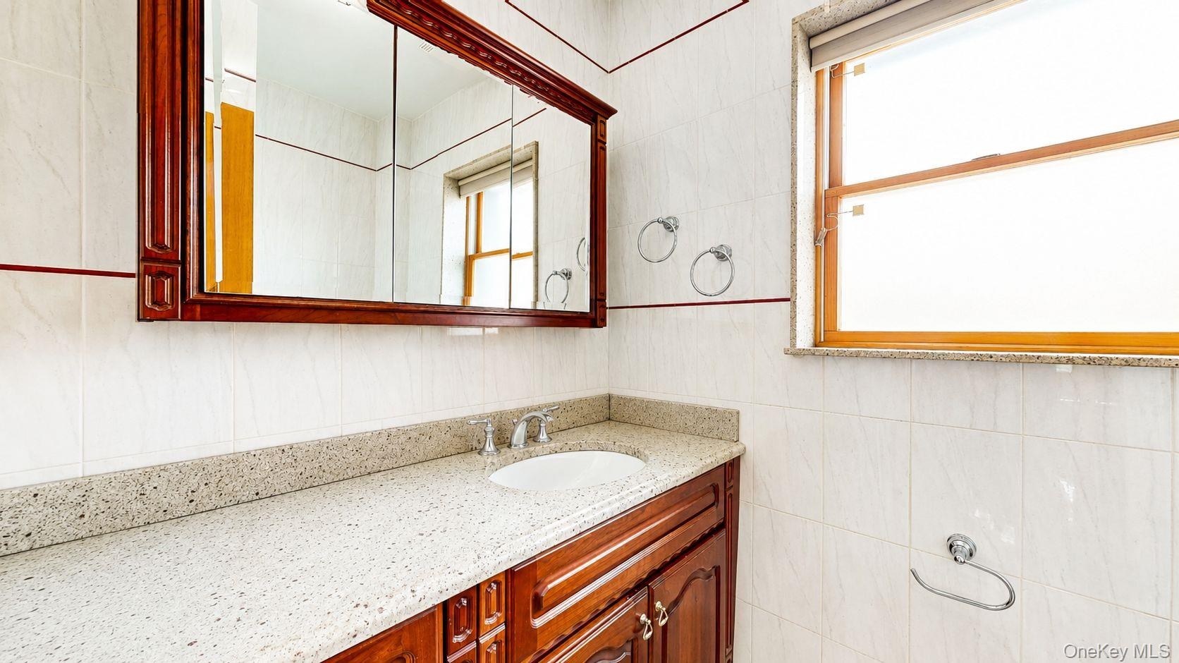 Vanity featuring a built-in sink, chrome faucet, and speckled countertop