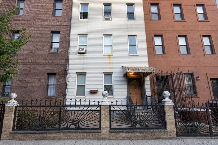 Three-story facade with light-colored siding