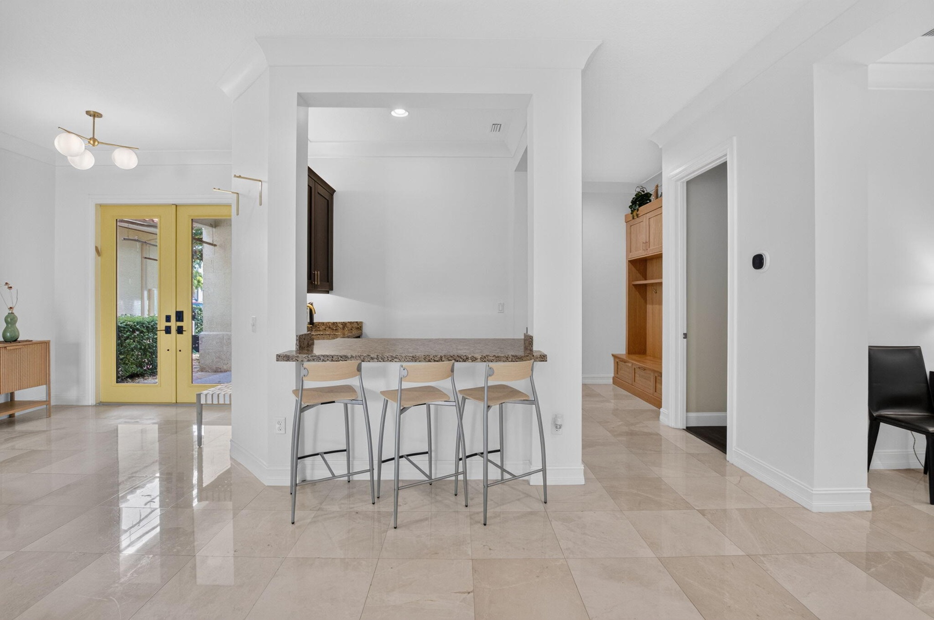 Kitchen pass-through with a stone countertop and dark wood cabinetry