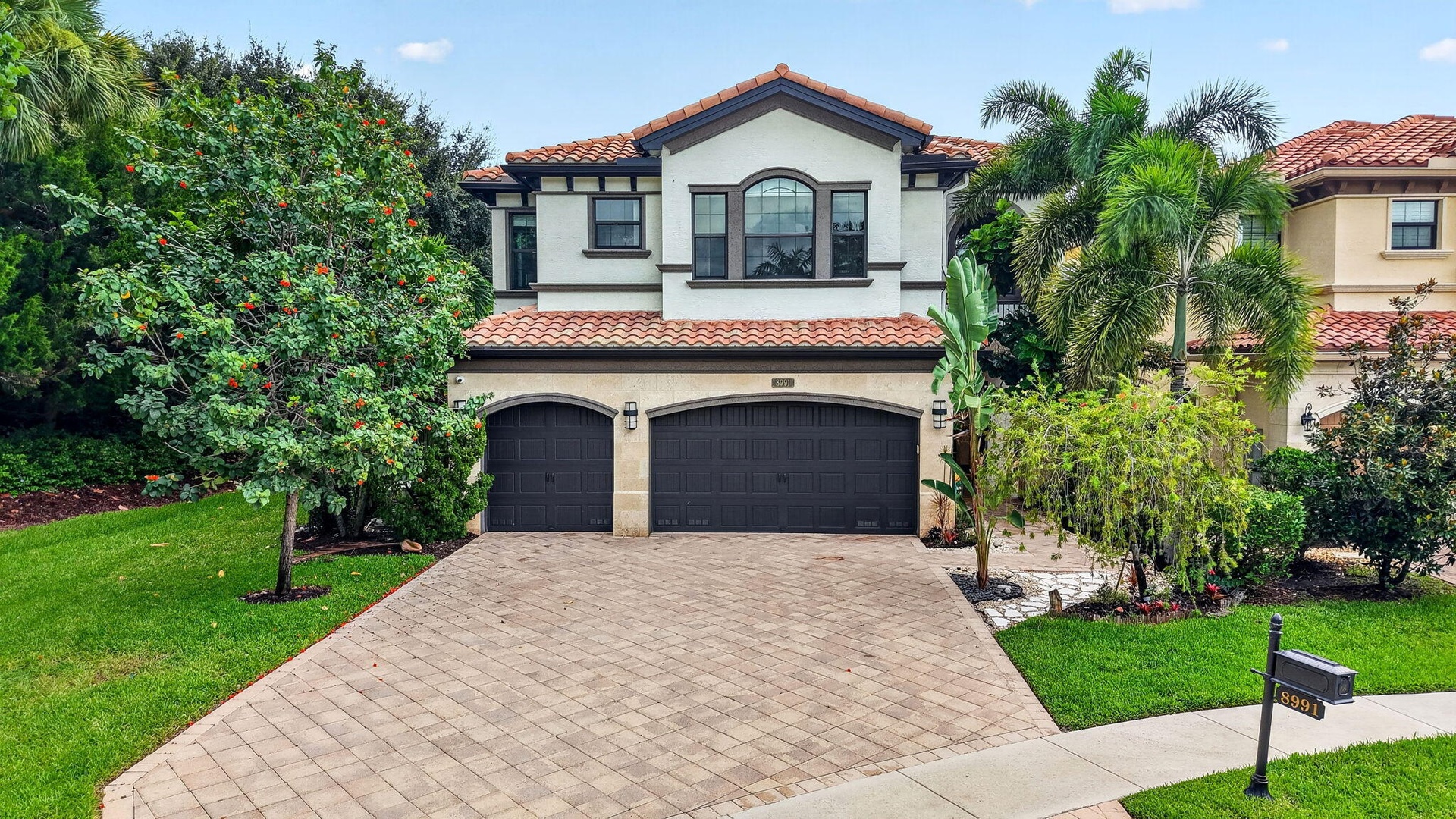 Mediterranean-style residence featuring a tile roof, stucco exterior, and arched entryway detailing