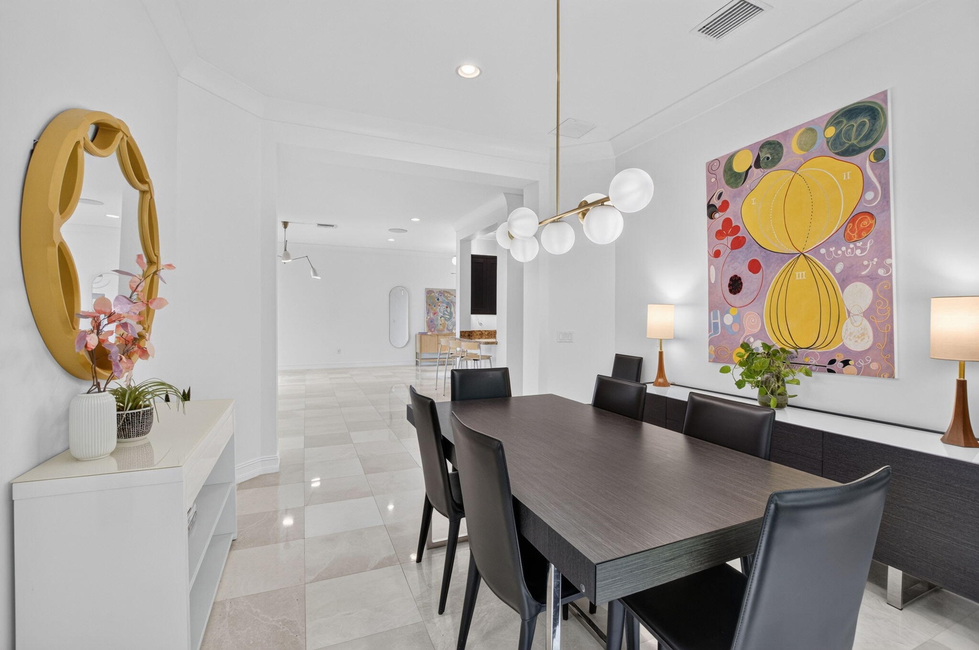 Spacious dining area featuring a linear pendant light fixture, large format tile flooring, and clean white walls