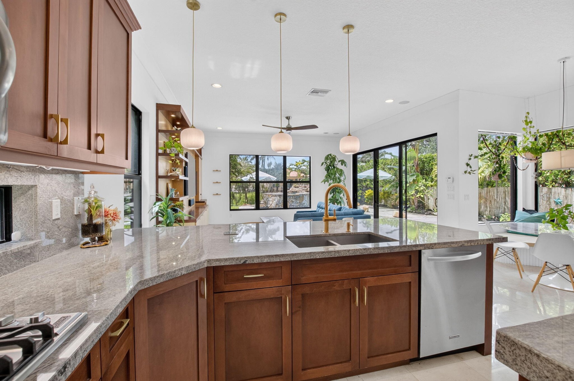 Spacious kitchen featuring a large island with dual sinks, wood-finish cabinetry, and light-toned countertops