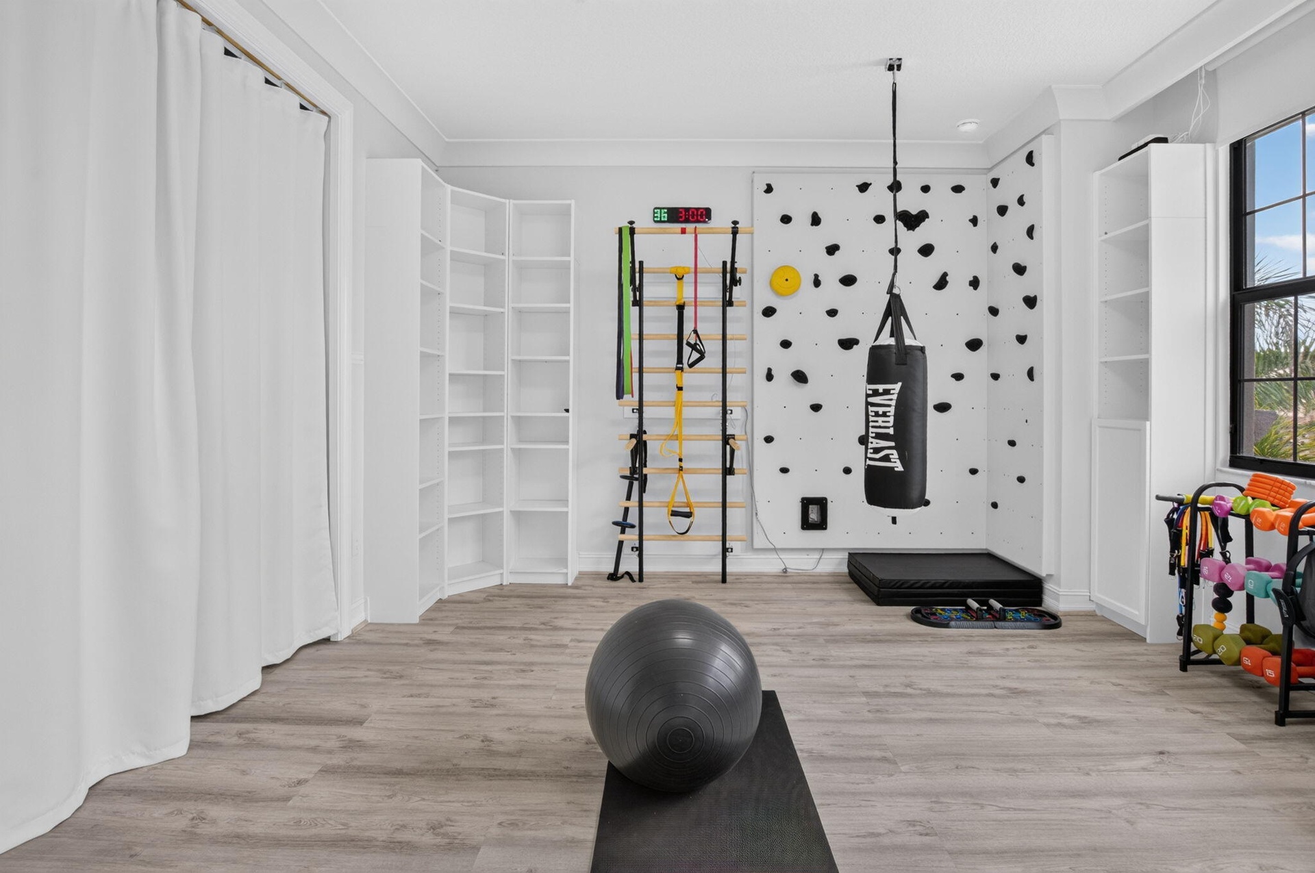 Spacious room featuring light wood-finish flooring and crown molding