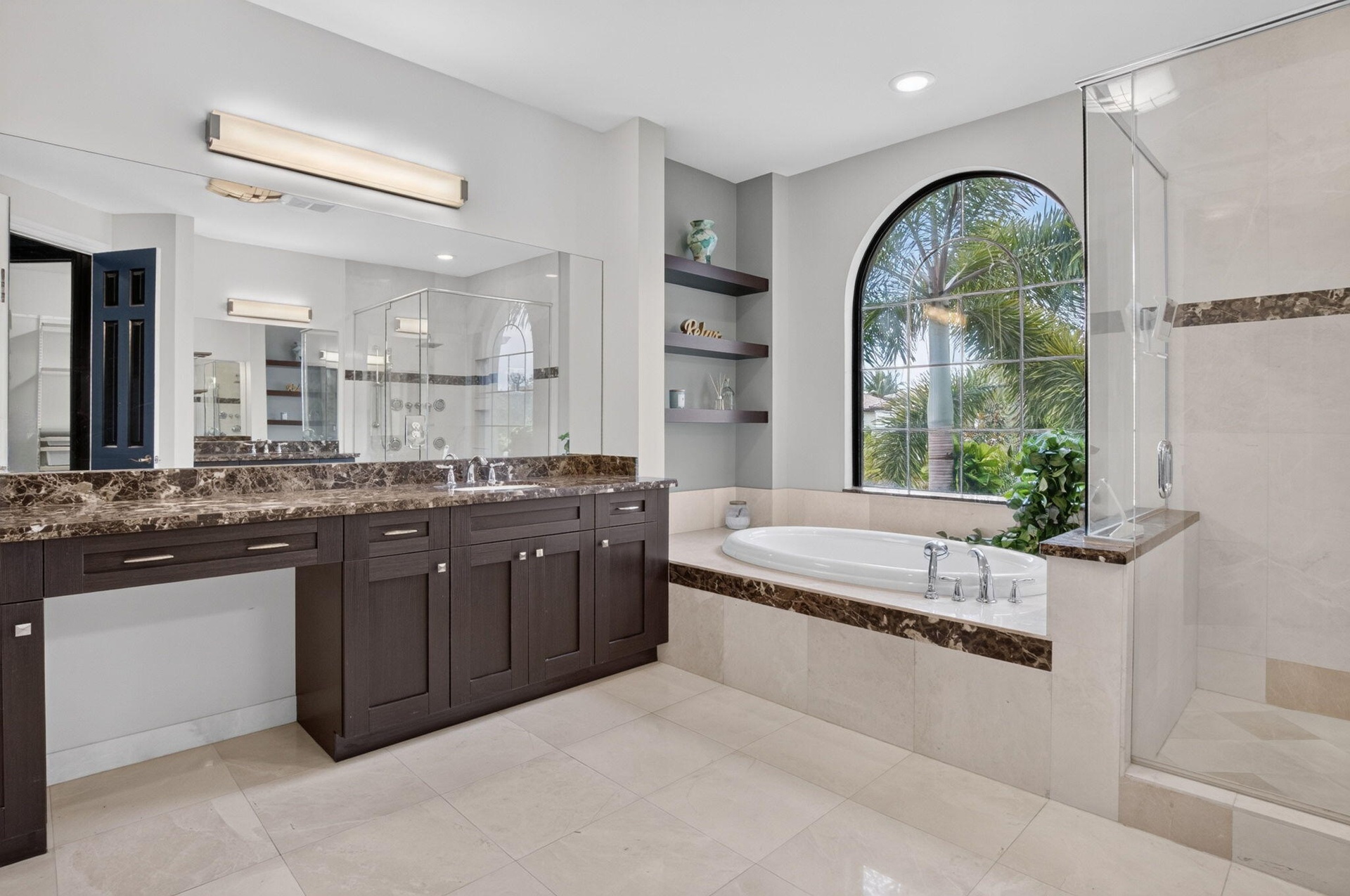 Bathroom featuring a built-in soaking tub beneath an arched window