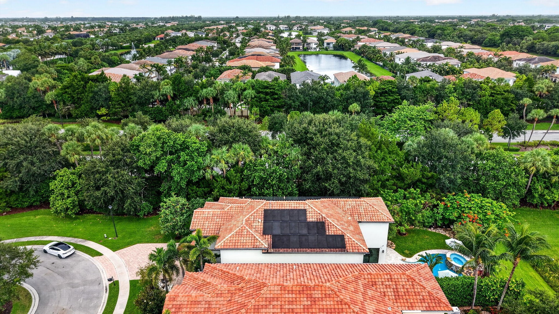 Tile roof residence featuring solar panels, a private pool, and spa