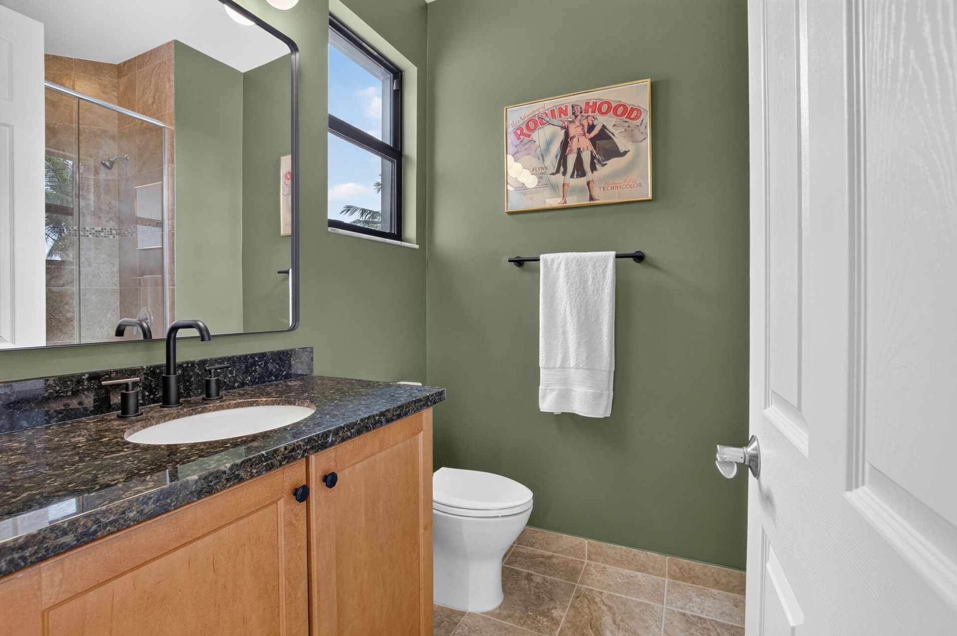 Bathroom vanity with a dark granite countertop, undermount sink, and matte black fixtures