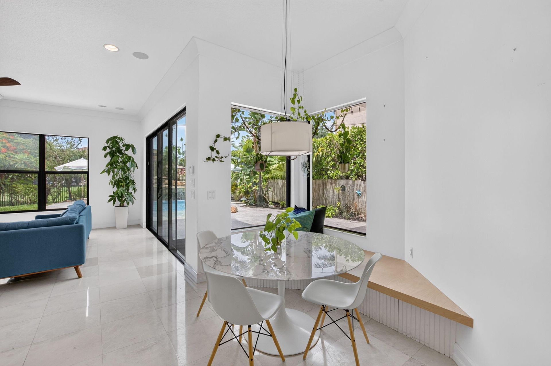 Integrated dining area featuring a built-in bench seating, large corner windows, and a modern pendant light fixture