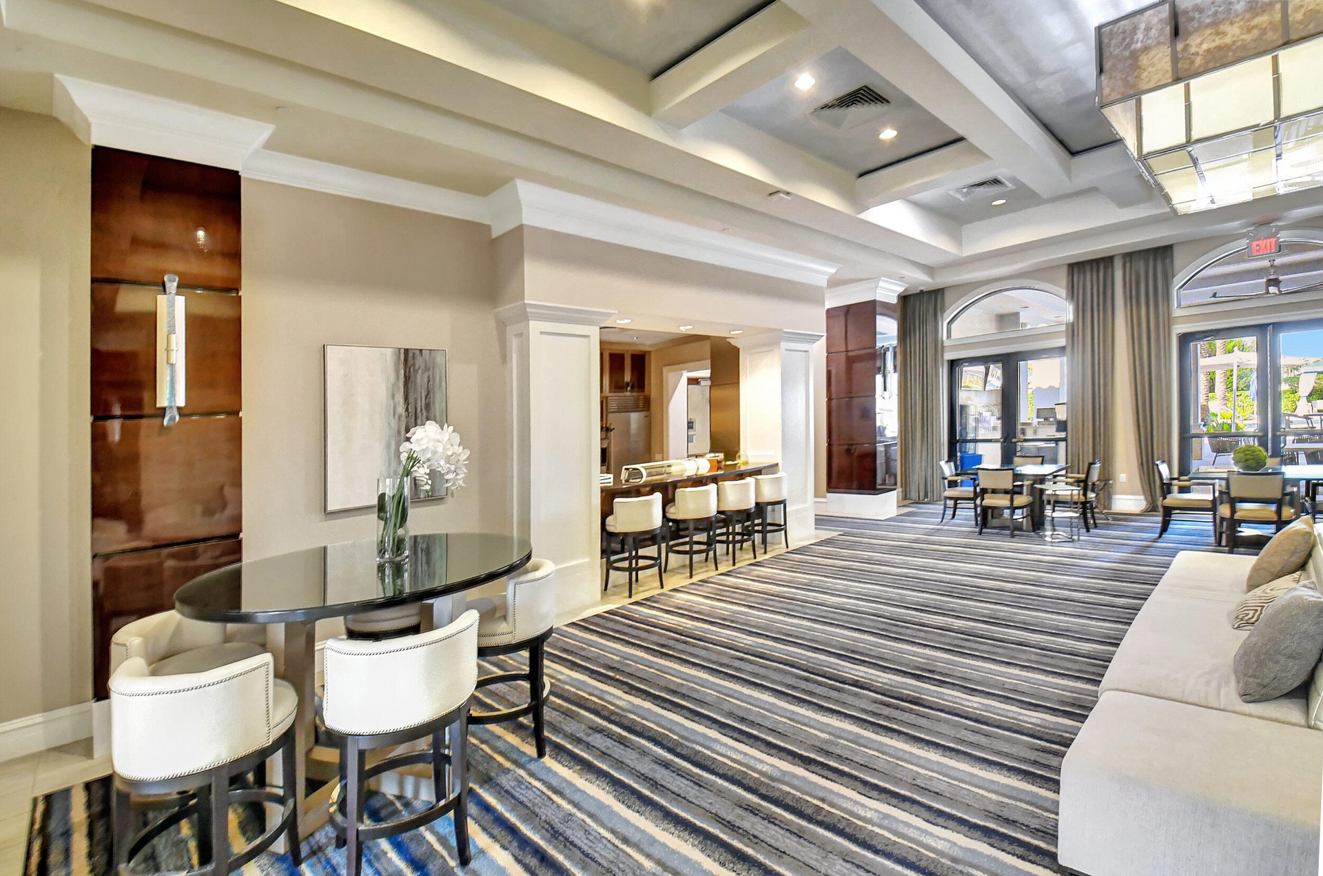 Spacious common area featuring a striped area rug, a built-in wet bar, and a selection of seating arrangements