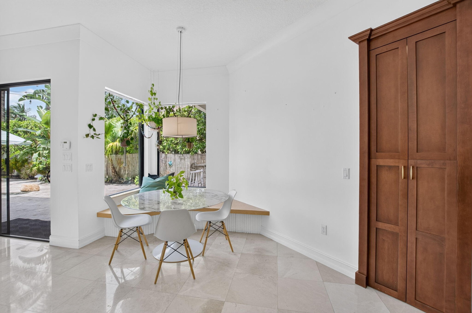 Corner dining area featuring large windows, a built-in bench, and a pendant light fixture