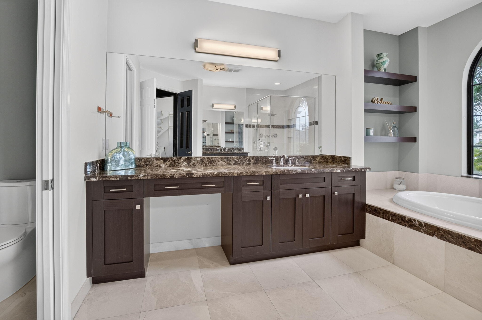 Dual vanity with an expansive countertop, integrated undermount sinks, and dark wood cabinetry