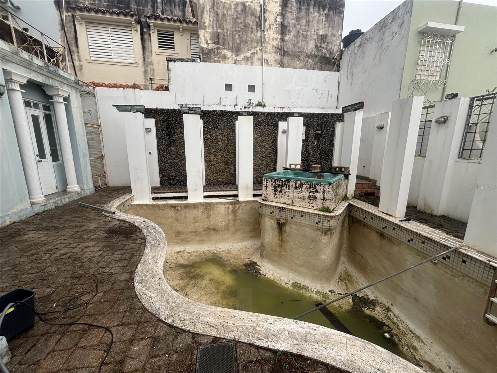 Original pool and spa design had trellises and a waterfall wall. It will require full renovation.