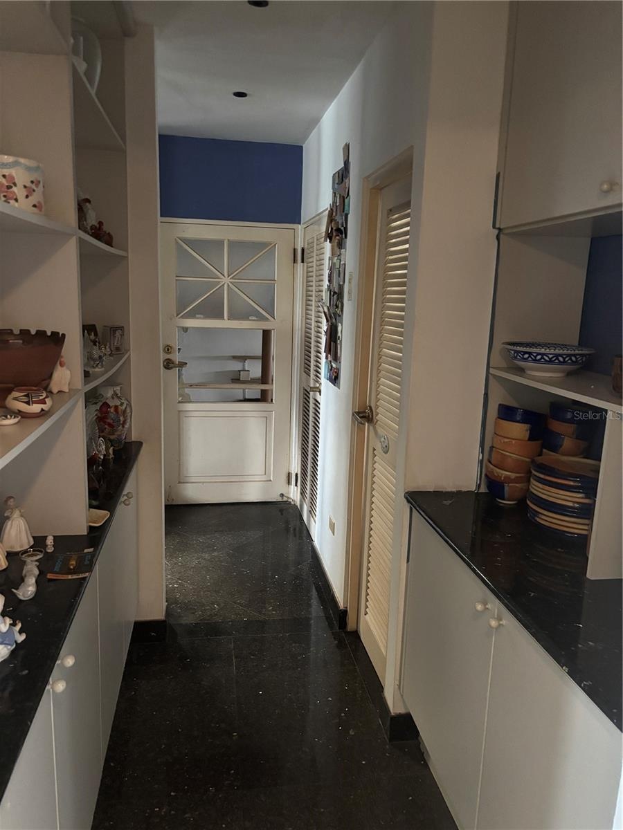 Hallway Pantry with half bath on the right, laundry room beyond and garage door at the end.