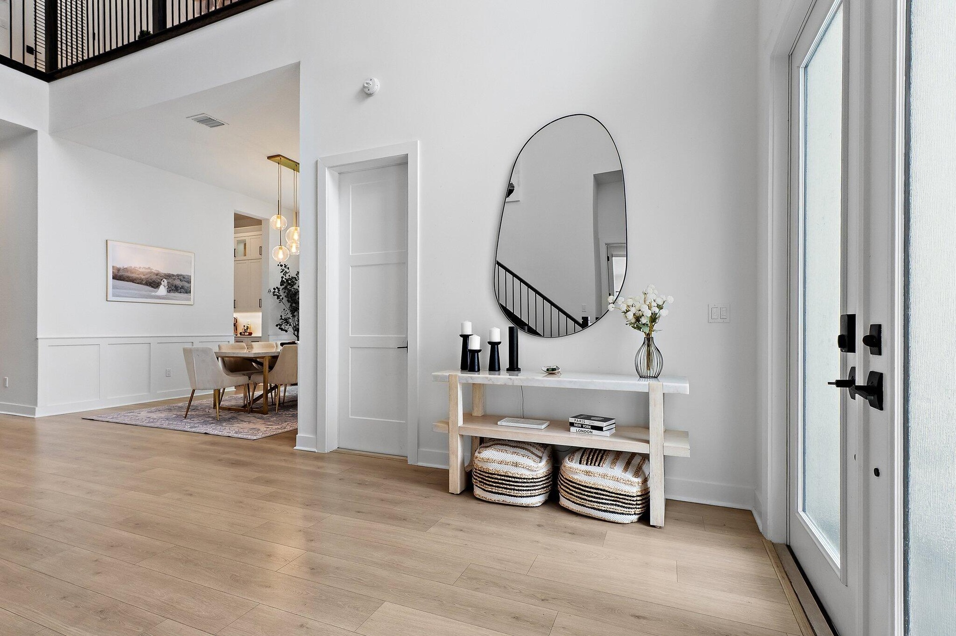 Entry hallway with console table, mirror, and staircase in background
