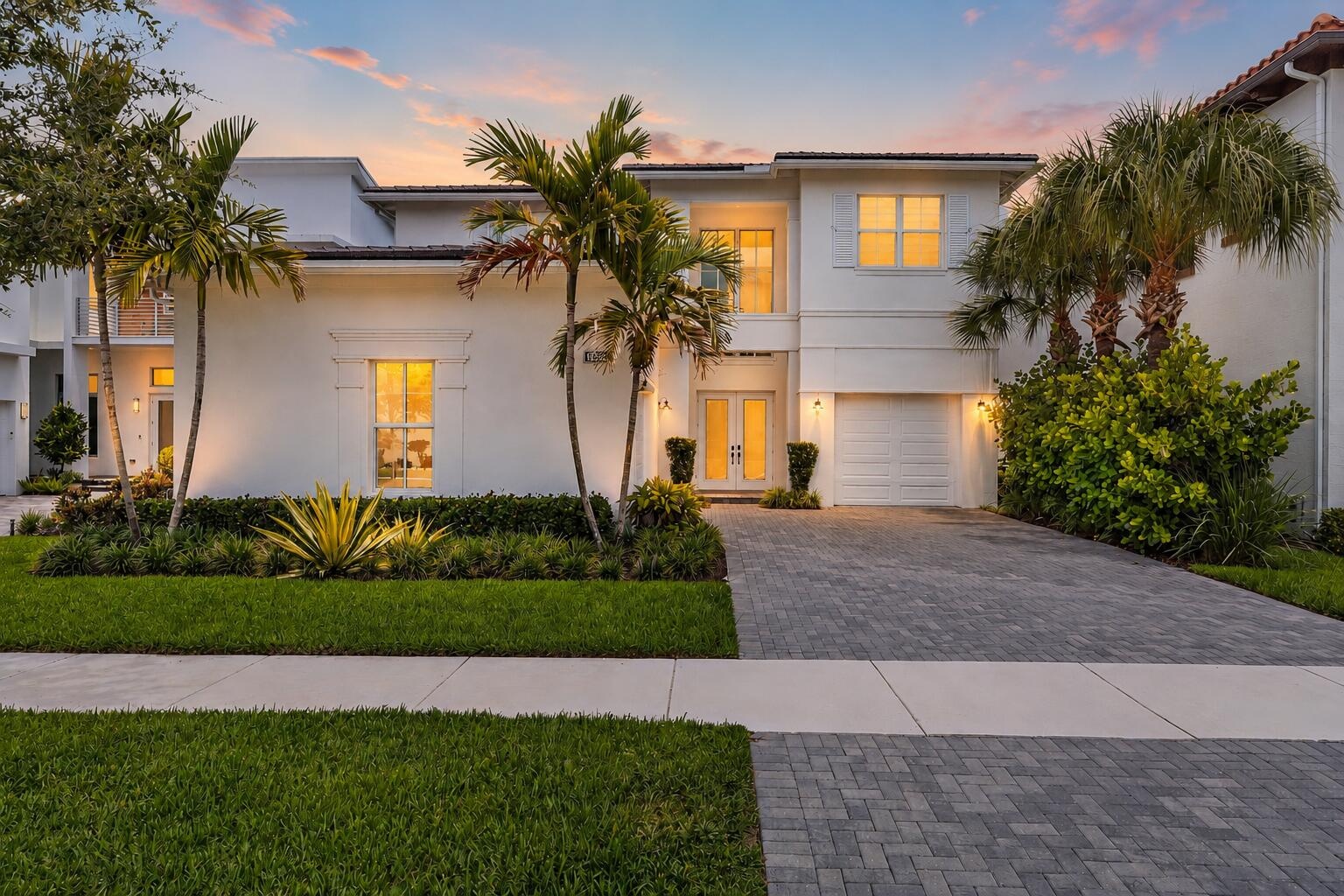 Front exterior view at dusk with garage and landscaped entrance