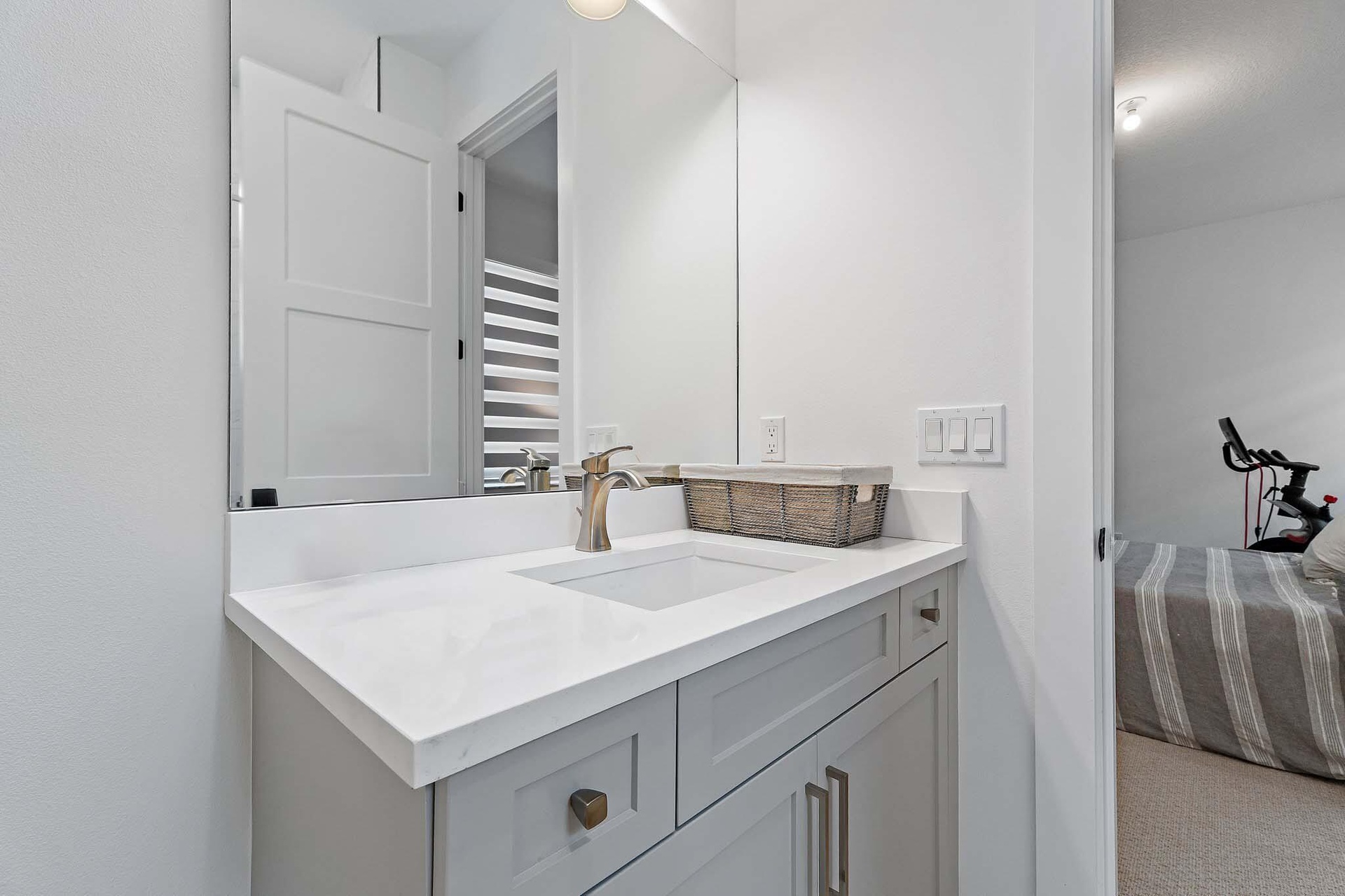 Bathroom with gray vanity, marble countertop, and mirror