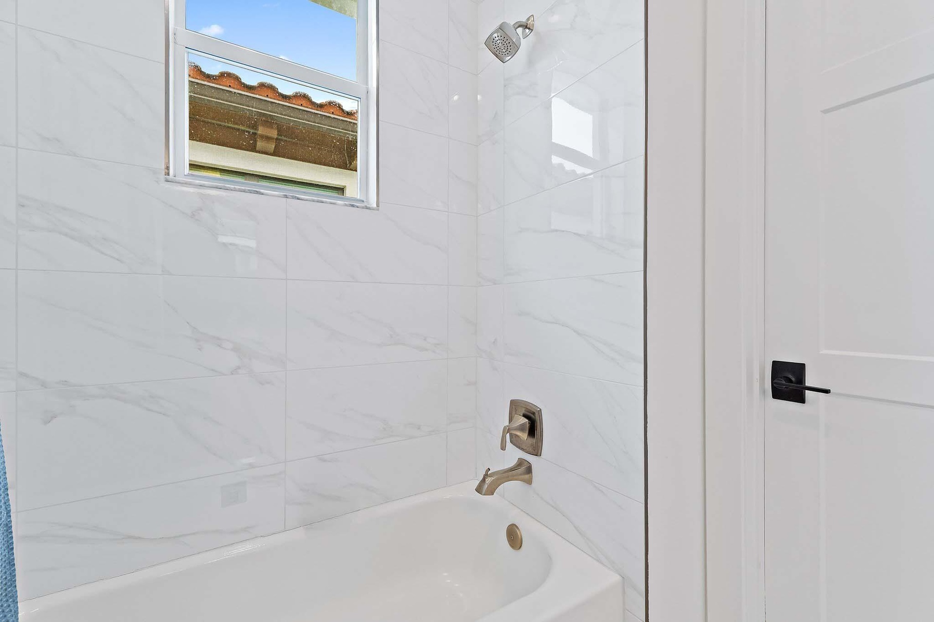Bathroom with tub and marble tile surround
