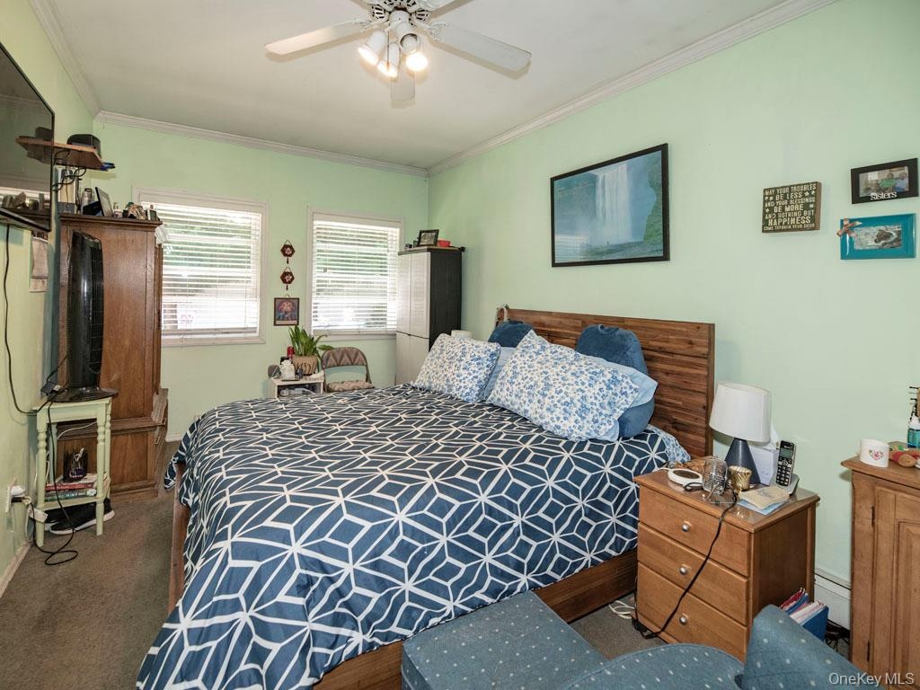 Bedroom featuring ornamental molding, ceiling fan, and carpet