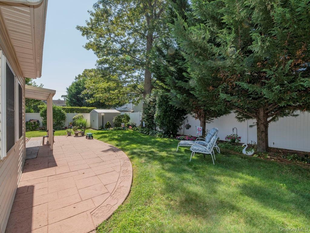 Fenced backyard with a patio area and a shed