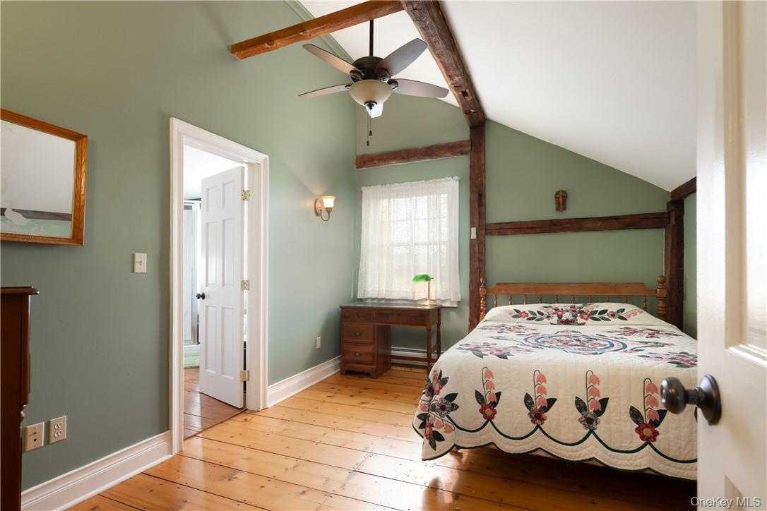 ceiling fan, vaulted ceiling with beams, and light hardwood floors