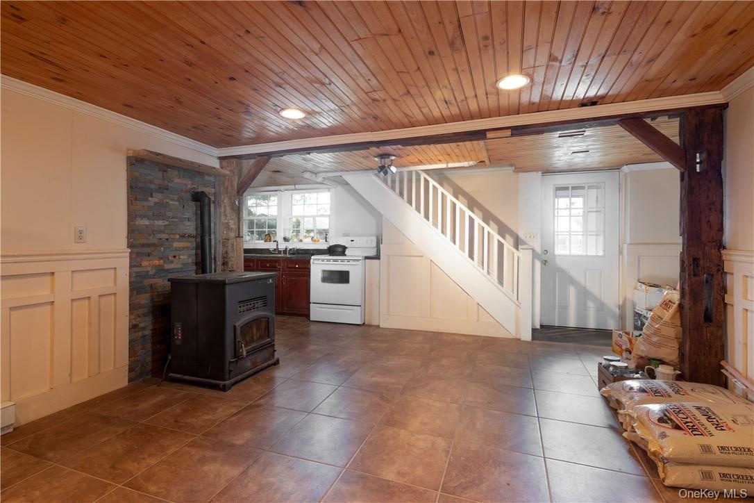 Laminate flooring. mini kitchen, wood ceiling, beam ceiling, and a pellet stove