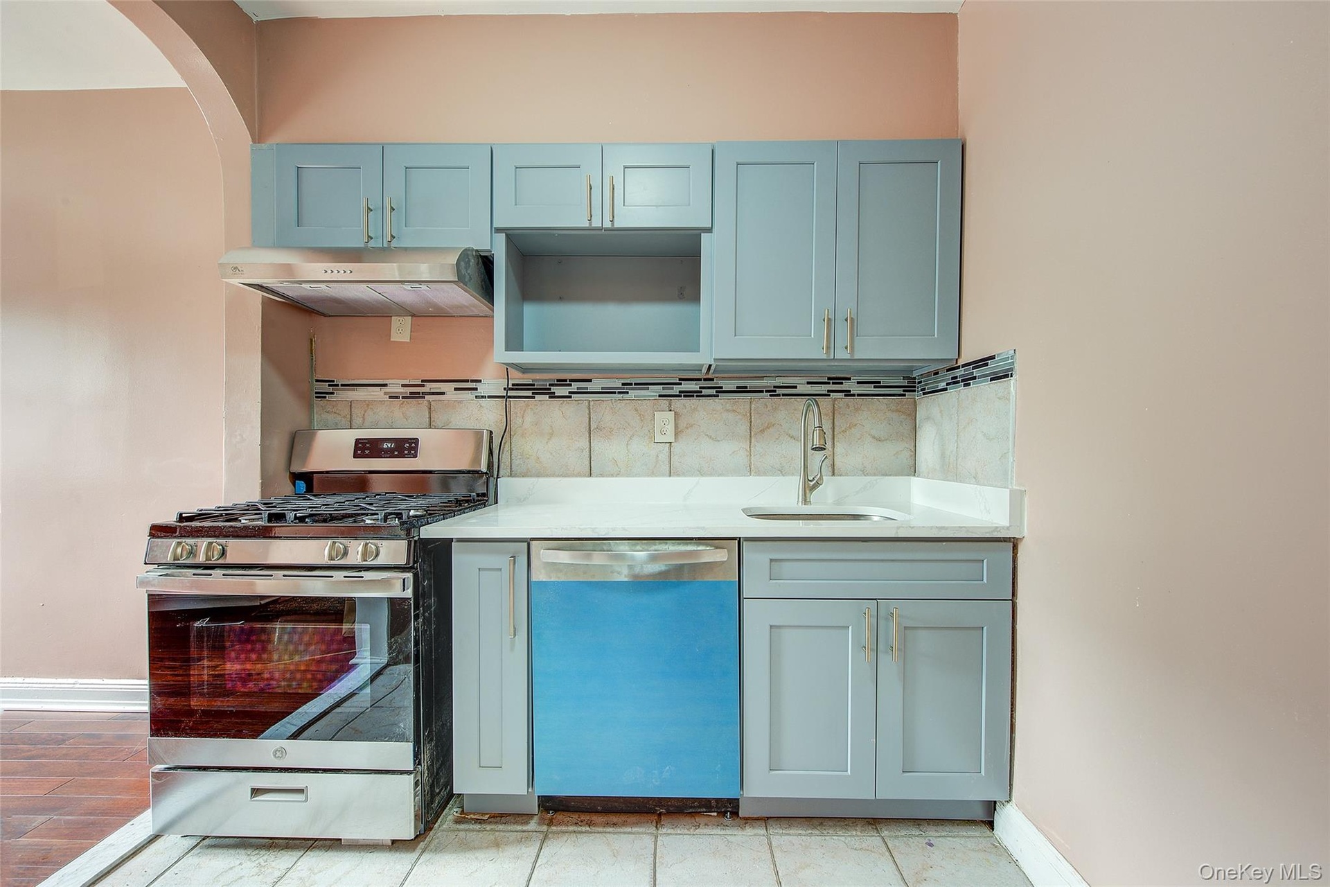 granite countertop, whirlpool stove, and dishwasher, tiled walls, gray on gold cabinets