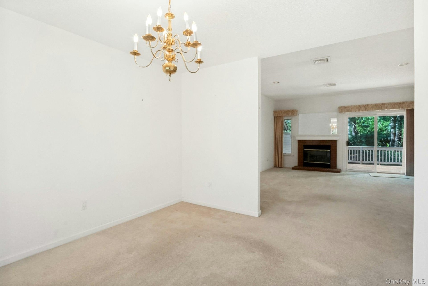 With view to living room with fireplace* & sliding glass doors to rear deck and yard*fireplace has not been used..