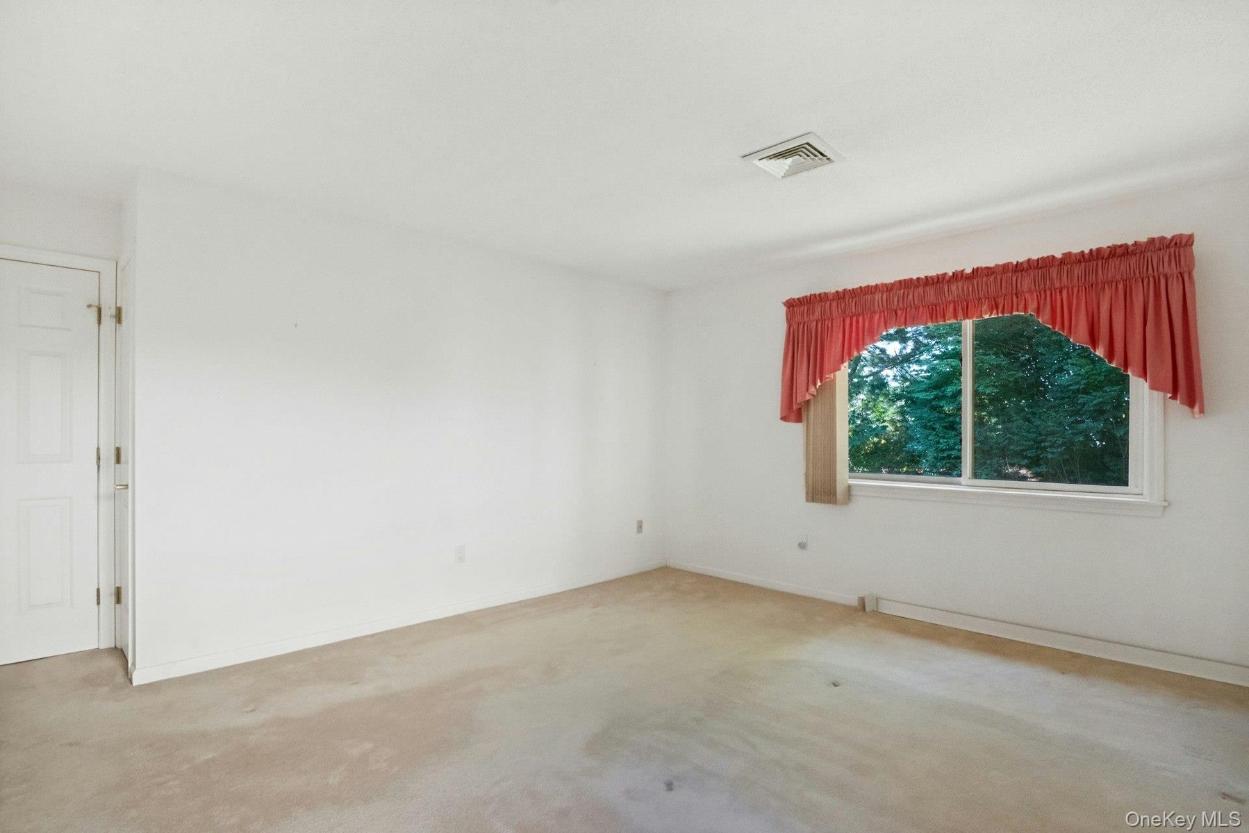 Primary bedroom showing more wall space and a linen closet & window facing the rear yard