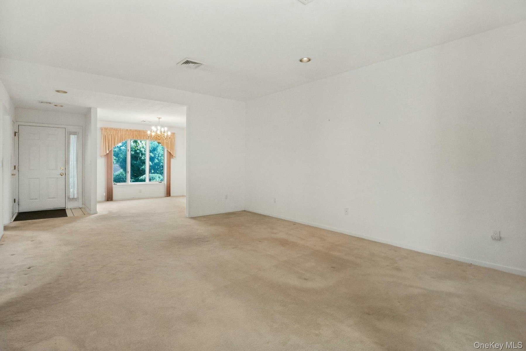 Long view of the living room to the dining area, & entry hall