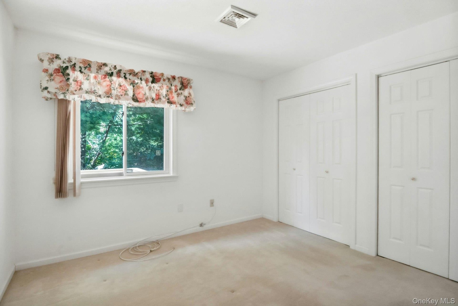 Second bedroom w view of the yard & double closets