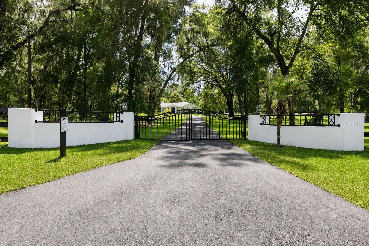 Mature oak trees and beautifully landscaped grounds create a private entrance to the property