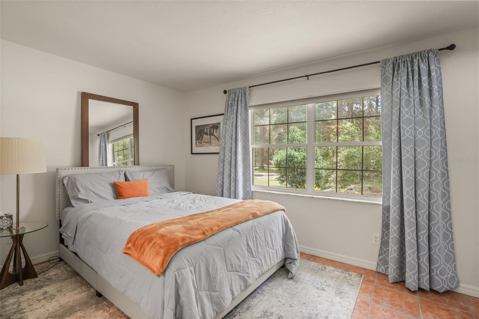 Guest bedroom with abundant natural light and scenic views of the surrounding landscape