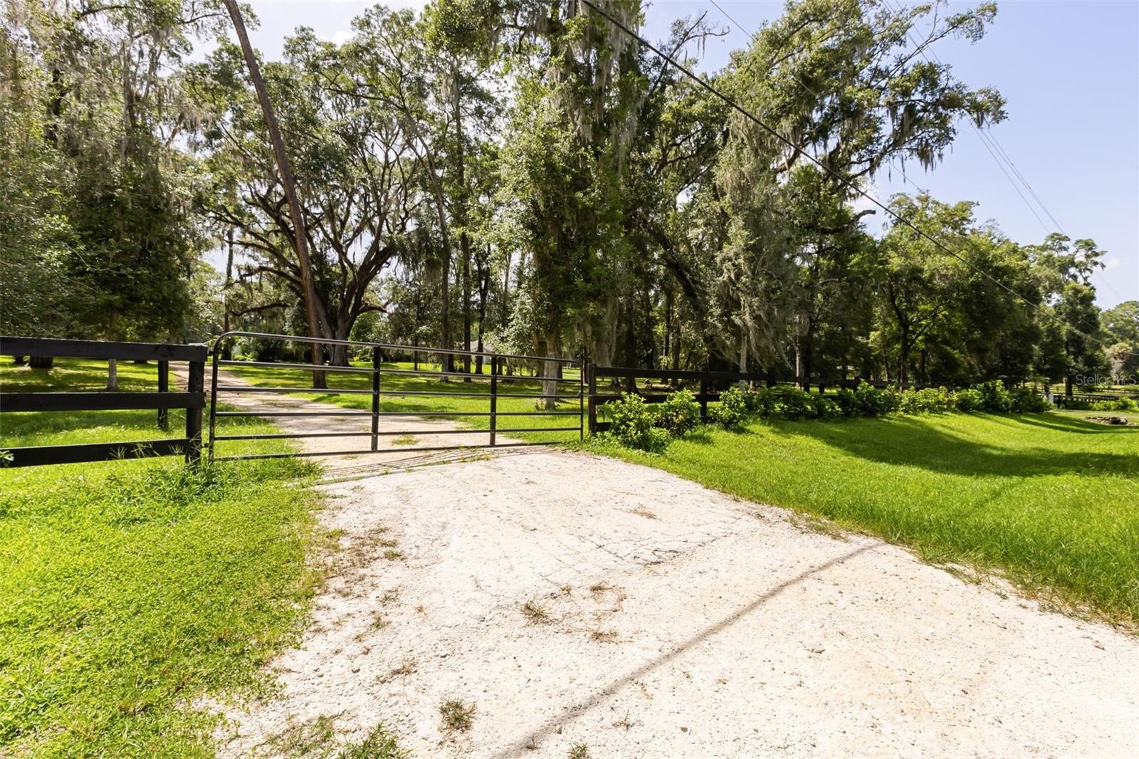 Additional entrance with brand-new limestone driveway leads through the property, offering easy access to the home and barns.