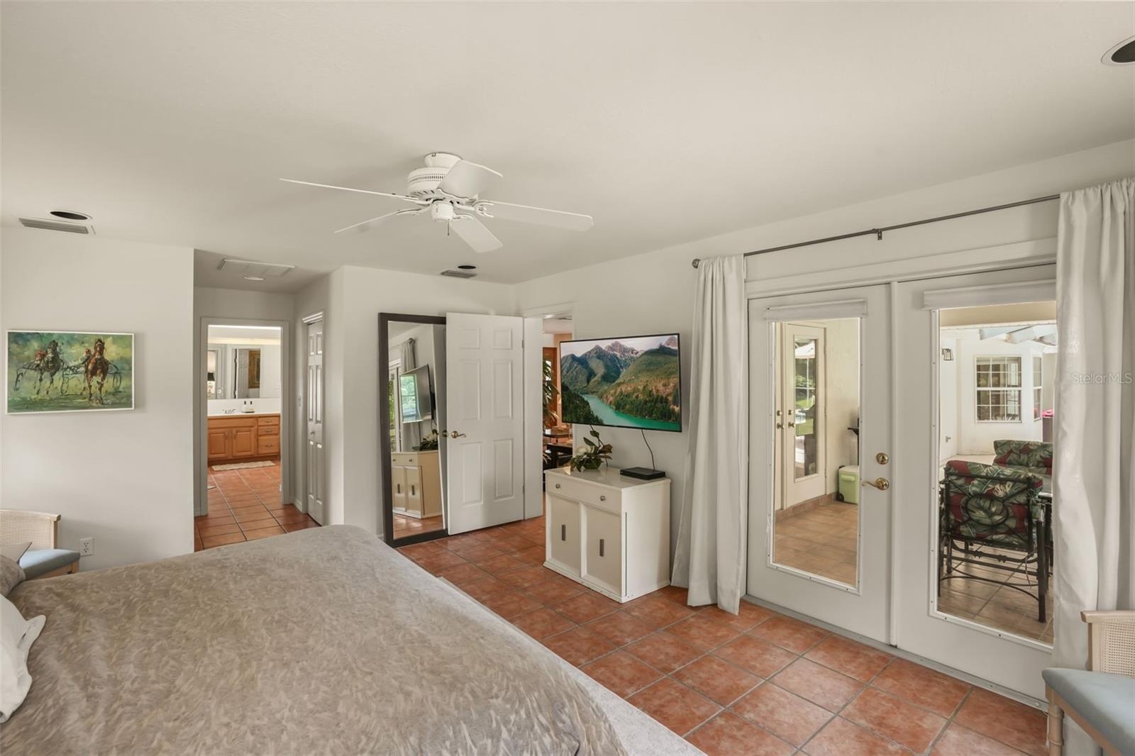 Primary suite offering direct access to the en-suite bathroom, walk-in closet, and pool deck