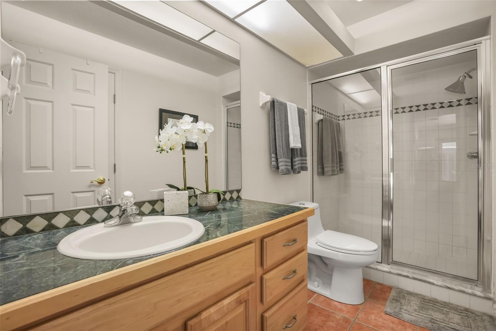 Guest bathroom featuring a spacious vanity and enclosed shower