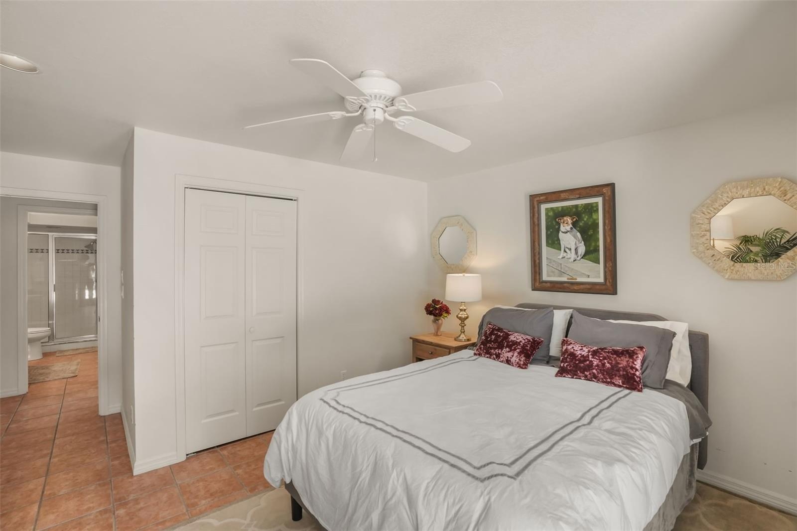 Comfortable guest bedroom featuring tile flooring and a spacious closet