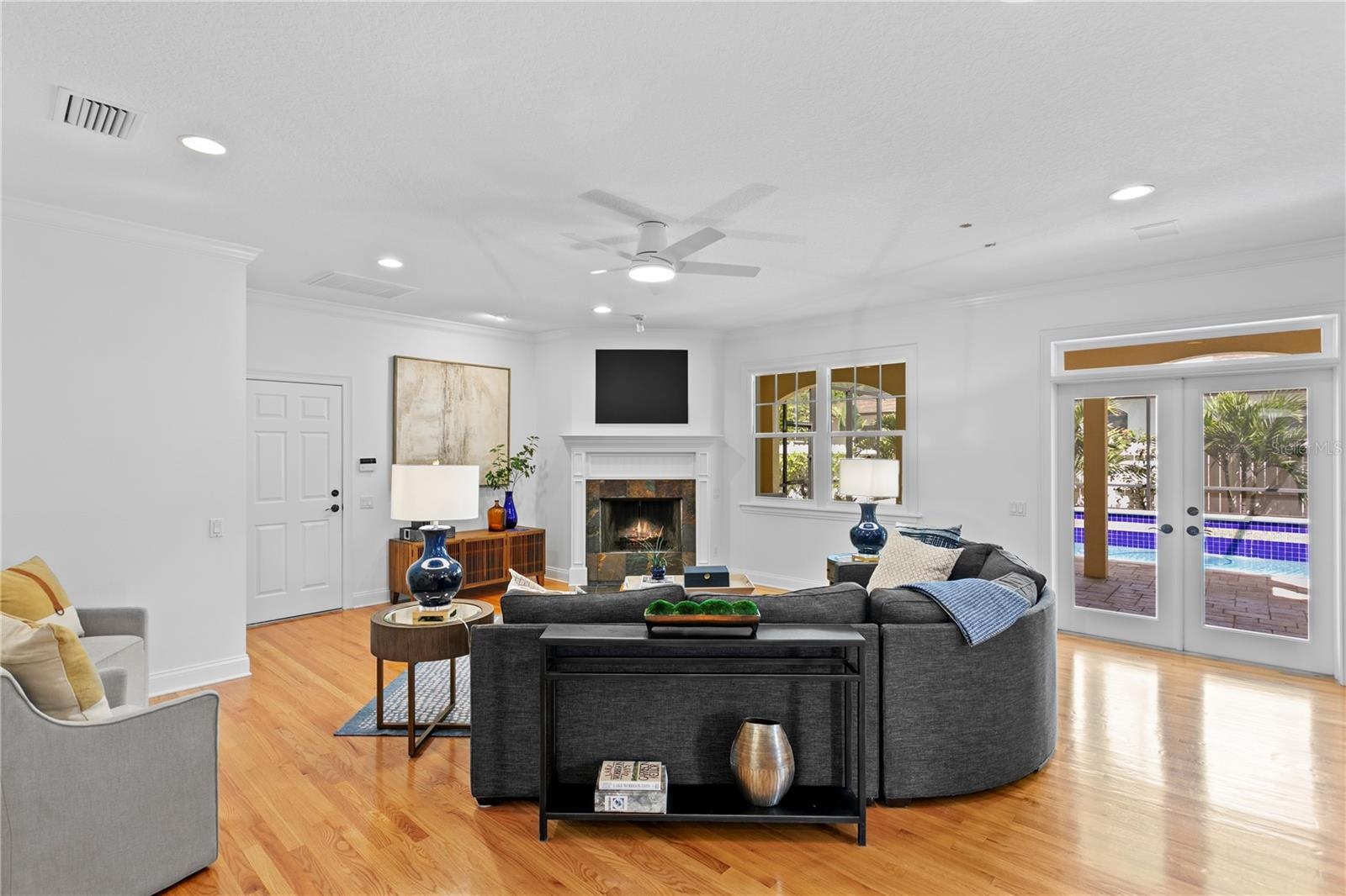The family room offers an enveloping warmth centered around a beautifully crafted fireplace, along with an open, intuitive layout that flows directly 