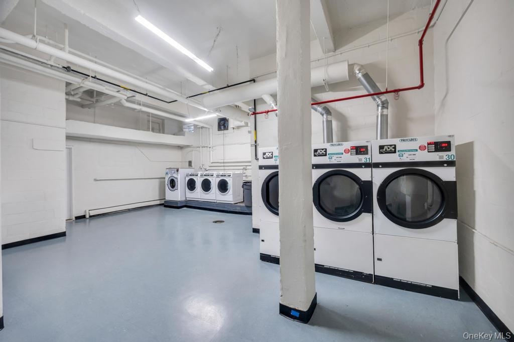 On-site laundry room featuring multiple commercial-grade washers and dryers